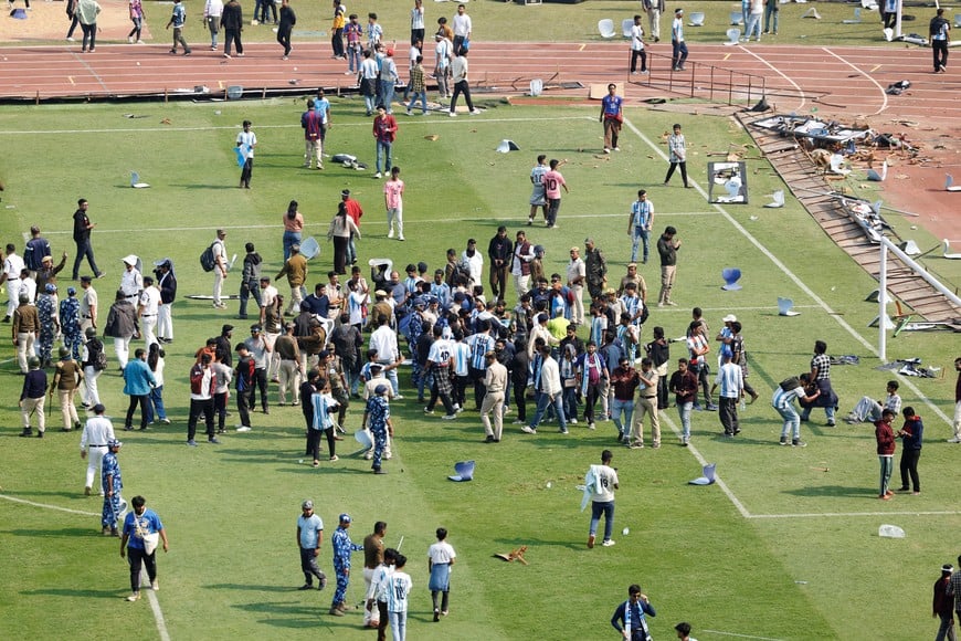 Soccer Football - Argentine soccer star Lionel Messi on a whirlwind tour of India - Vivekananda Yuva Bharati Krirangan, Kolkata, India - December 13, 2025
Riot police and fans are seen on the pitch after Argentine soccer star Lionel Messi leaves the stadium REUTERS/Sahiba Chawdhary