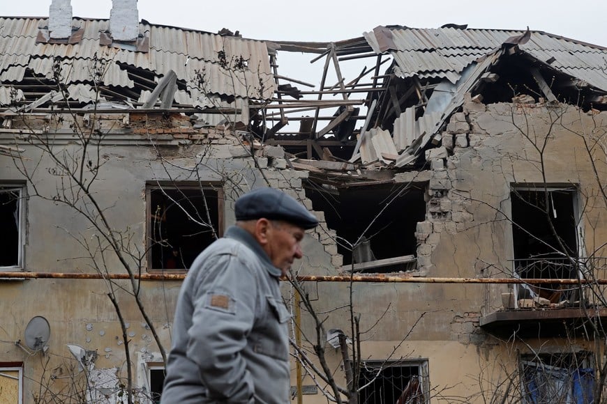 A man walks past an apartment building, which was damaged during what Russian-installed authorities described as a Ukrainian overnight drone attack, in the course of Russia-Ukraine conflict in Donetsk, a Russian-controlled city of Ukraine, November 30, 2025. REUTERS/Alexander Ermochenko