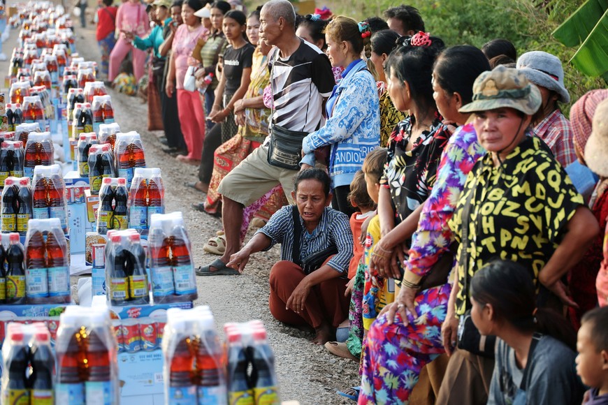 People wait to receive supplies at Wat Por Sovannaram refugee camp, amid clashes between Thailand and Cambodia along a disputed border area, in Ou Chrov district, Banteay Meanchey Province, Cambodia, December 13, 2025. REUTERS/Kim Hong-Ji