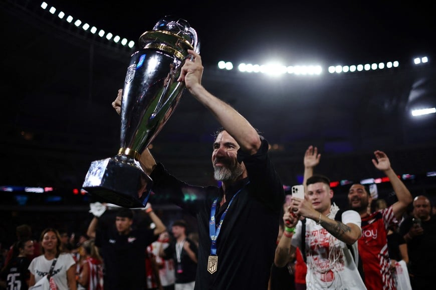 Soccer Football - Argentine Primera Division - Torneo Clausura - Racing Club v Estudiantes de La Plata - Estadio Unico Madre de Ciudades, Santiago del Estero, Argentina - December 14, 2025
Estudiantes de La Plata coach Eduardo Dominguez celebrates with the trophy after winning the Argentine Primera Division REUTERS/Agustin Marcarian