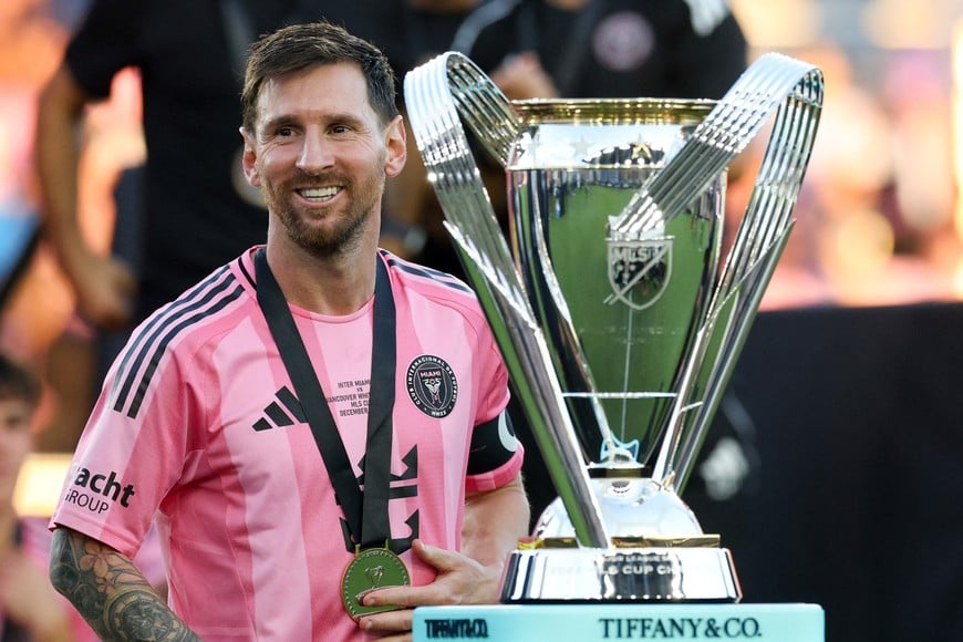Dec 6, 2025; Fort Lauderdale, Florida, USA; Inter Miami forward Lionel Messi (10) looks on with the Philip F. Anschutz trophy after winning the 2025 MLS Cup against the Vancouver Whitecaps FC at Chase Stadium. Mandatory Credit: Nathan Ray Seebeck-Imagn Images