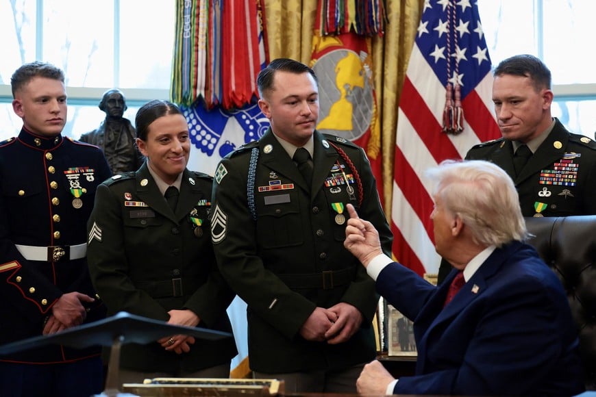 U.S. President Donald Trump speaks to U.S. Army service members during a Mexican Border Defense Medal presentation in the Oval Office at the White House in Washington, D.C., U.S., December 15, 2025. REUTERS/Evelyn Hockstein