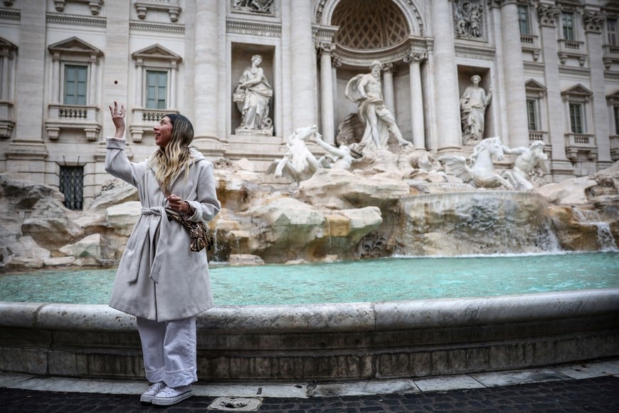Sofia Paz, from Chile, throws a coin into the Trevi Fountain in Rome, Italy, February 19, 2024. As visitors' coins splash into Rome's majestic Trevi Fountain carrying wishes for love, good health or a return to the Eternal City, they provide practical help to people the tourists will never meet. For hundreds of years, when in Rome, visitors have flocked to the fountain to make a wish, following a storied ritual. Few gave their coins a second thought. Today, coins pile up for several days before they are fished out and taken to the Rome division of the worldwide Catholic charity Caritas, which counts the bucketfuls of change and uses them to fund a food bank, soup kitchen and welfare projects. "I am tossing the coin because my brother is ill, and I am making a wish he can get better soon," Paz said. REUTERS/Guglielmo Mangiapane SEARCH "MANGIAPANE FOUNTAIN COINS" FOR THIS STORY. SEARCH "WIDER IMAGE" FOR ALL STORIES.