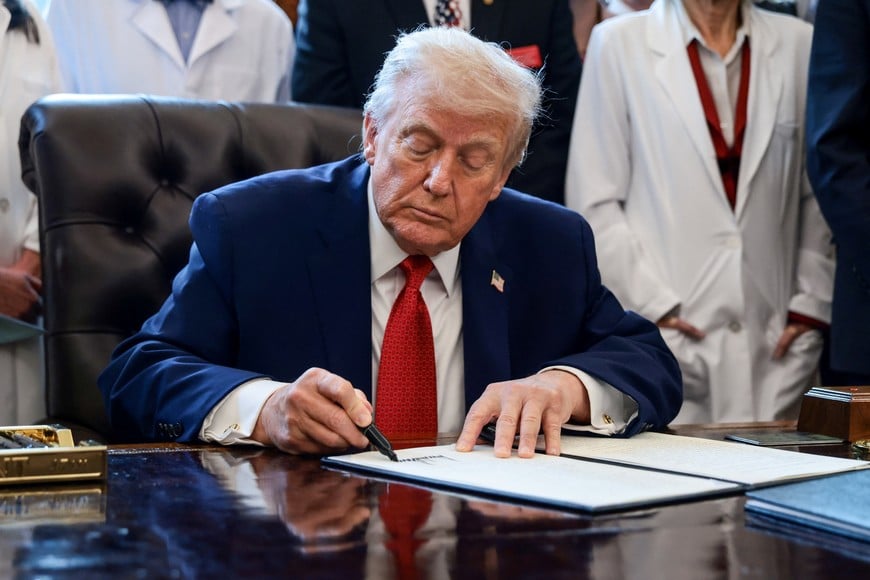 U.S. President Donald Trump signs an executive order recommending loosening the federal regulations on marijuana, in the Oval Office at the White House in Washington, D.C., U.S., December 18, 2025. REUTERS/Evelyn Hockstein