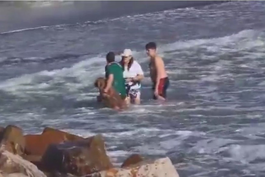 El "héroe" de la mañana llevando al perro con su familia.