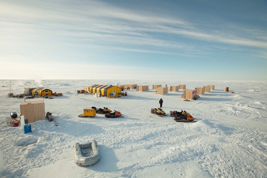 REUTERS PICTURES 40th ANNIVERSARY COLLECTION:  A man walks towards snow machines past the plywood hutches and tents that make up the Applied Physics Lab Ice Station in the Arctic north of Prudhoe Bay, Alaska March 18, 2011.  REUTERS/Lucas Jackson  SEARCH "REUTERS PICTURES 40th ANNIVERSARY COLLECTION" FOR THIS PACKAGE