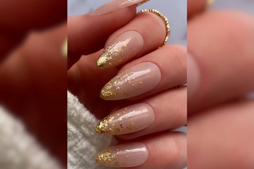 El dorado en las uñas suma brillo y sofisticación a cualquier outfit navideño.
