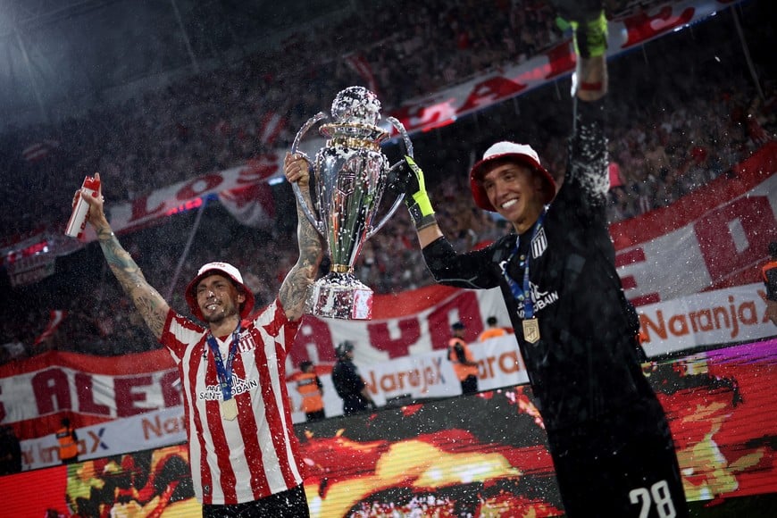 Soccer Football - Argentine Primera Division - Torneo Clausura - Racing Club v Estudiantes de La Plata - Estadio Unico Madre de Ciudades, Santiago del Estero, Argentina - December 14, 2025
Estudiantes de La Plata's Lucas Piovi and Fernando Muslera celebrate with the trophy after winning the Argentine Primera Division REUTERS/Agustin Marcarian