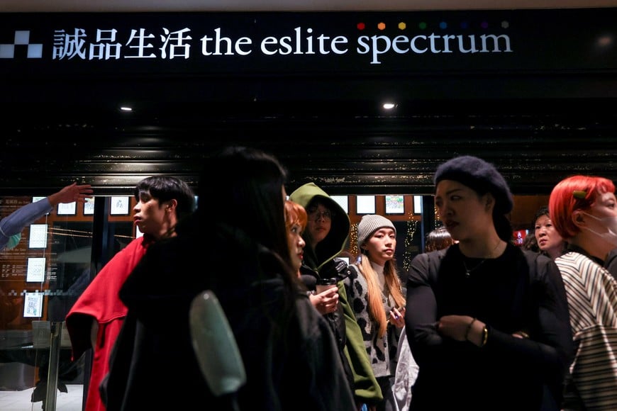 Staff from Eslite Spectrum Nanxi store near Zhongshan station wait to return to the building to collect their personal belongings while the building is cordoned off with yellow crime scene tape, following an incident in which several were injured after a person released smoke bombs and attacked bystanders, according to the government and local media, in Taipei, Taiwan, December 19, 2025. REUTERS/Ann Wang