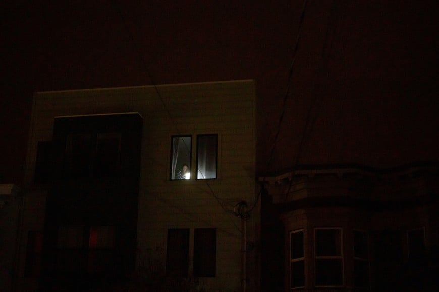 A person uses a flashlight inside an apartment during a blackout that affected about 130,000 residents, according to Pacific Gas and Electric Company in San Francisco, California, U.S., December 21, 2025. REUTERS/Carlos Barria