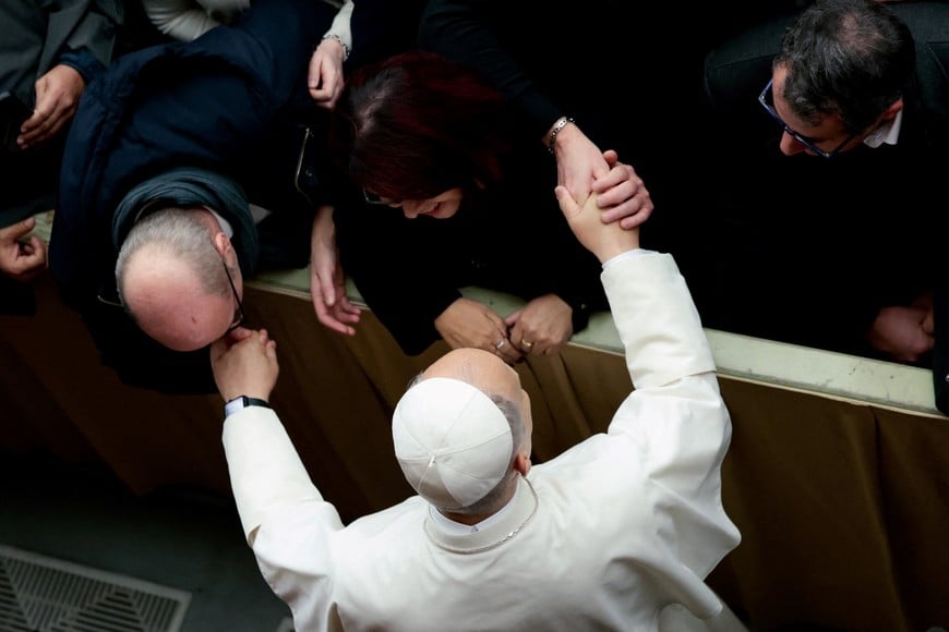 Pope Leo XIV greets the audience at the end of a meeting with employees of the Roman Curia, the Governorate of the Vatican City State, and the Vicariate of Rome and their families for the exchange of Christmas greetings, in Paul VI Hall at the Vatican, December 22, 2025. REUTERS/Remo Casilli
