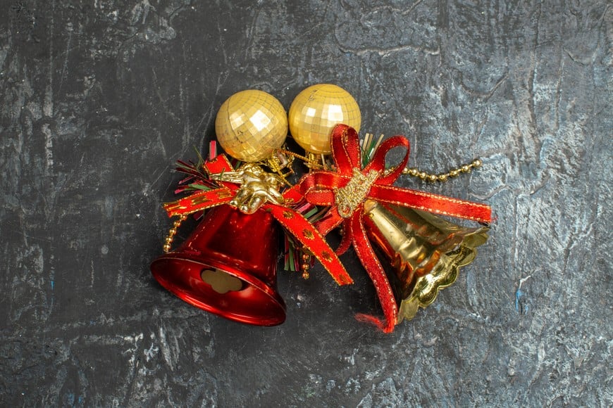 Una campana con cinta roja en la puerta simboliza protección y prosperidad en el hogar.