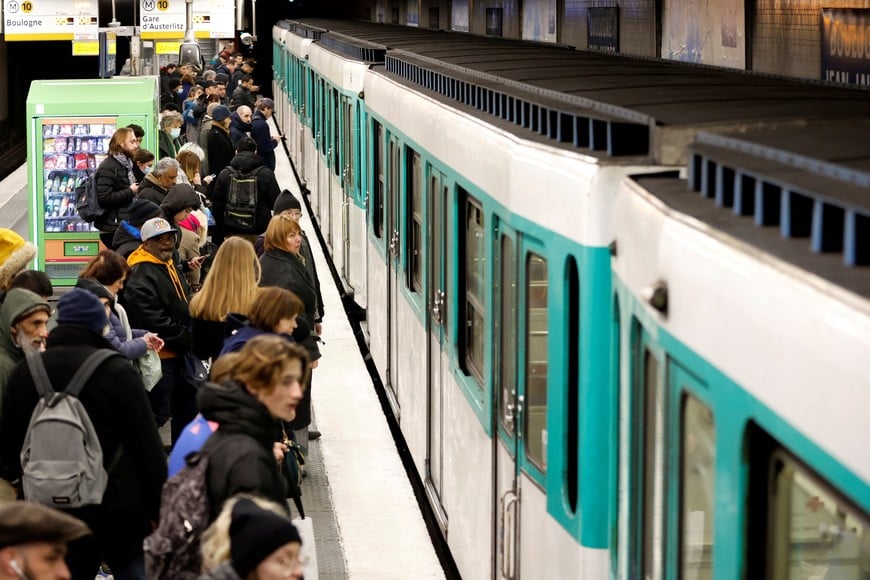 Passengers wait for the metro operated by the Paris transport network RATP inside a subway station in Boulogne-Billancourt near Paris on the eve of a nationwide day of strike and protests in key sectors like energy, public transport, air travel and schools against the pension reform in France, January 18, 2023.  REUTERS/Gonzalo Fuentes
