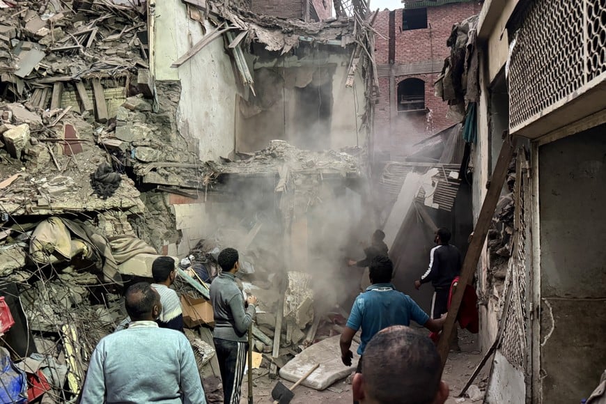 (251225) -- EL CAIRO, 25 diciembre, 2025 (Xinhua) -- Rescatistas trabajan entre los escombros de un edificio derrumbado, en Guiza, Egipto, el 25 de diciembre de 2025. La cifra de muertes a causa del derrumbe de un edificio residencial de cinco pisos en la provincia de Guiza de Egipto, al sur de El Cairo, aumentó a ocho, informó el  jueves el sitio web de noticias estatal egipcio Ahram Online. (Xinhua/Ahmed Gomaa) (da) (ra) (vf)