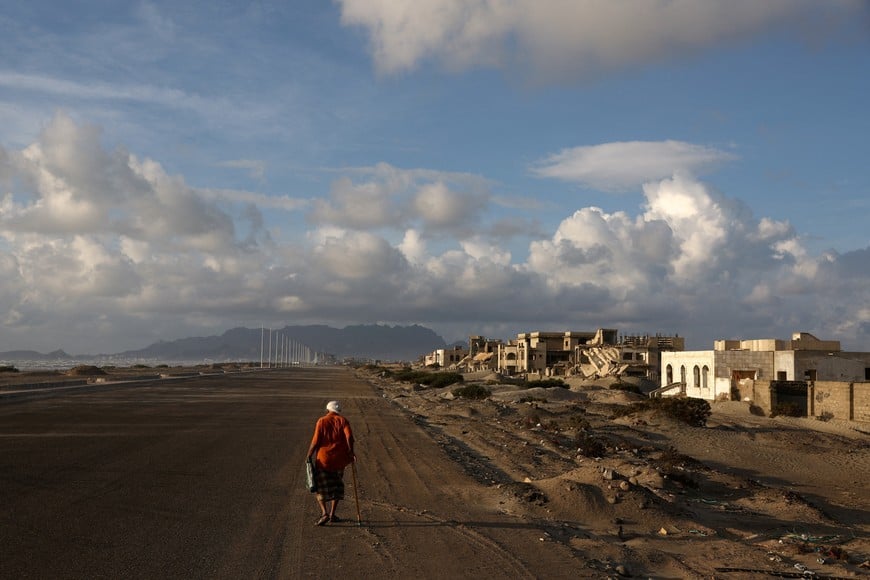 A Yemeni man walks past buildings damaged or destroyed during the civil war, in Aden, Yemen, October 26, 2024. REUTERS/Amr Alfiky     To match Special Report YEMEN-HOUTHIS/POVERTY     TPX IMAGES OF THE DAY