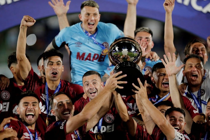 Soccer Football - Copa Sudamericana - Final - Lanus v Atletico Mineiro - Estadio Defensores del Chaco, Asuncion, Paraguay - November 22, 2025 
Lanus' Carlos Izquierdoz, Lautaro Acosta and teammates celebrate with the trophy after winning the Copa Sudamericana final REUTERS/Cesar Olmedo