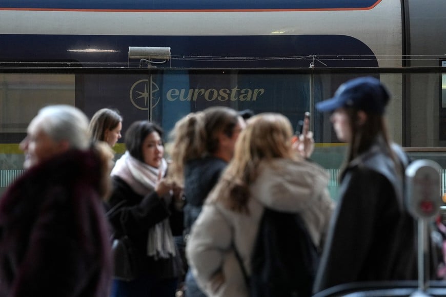 Passengers stand near a Eurostar train carriage, after a Eurostar spokesperson said they were suspending its cross-Channel train services to and from London until further notice following a power supply problem in the Channel Tunnel that links Britain and France, at St. Pancras International station in London, Britain, December 30, 2025. REUTERS/Maja Smiejkowska