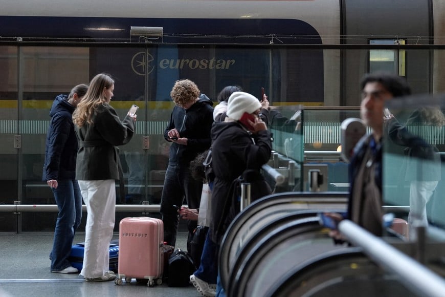 Passengers stand near a Eurostar train carriage, after a Eurostar spokesperson said they were suspending its cross-Channel train services to and from London until further notice following a power supply problem in the Channel Tunnel that links Britain and France, at St. Pancras International station in London, Britain, December 30, 2025. REUTERS/Maja Smiejkowska