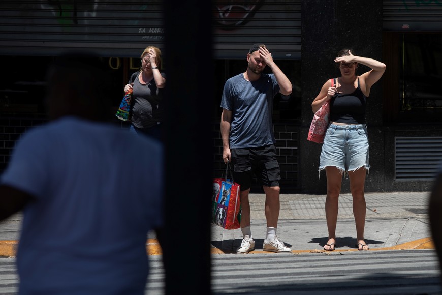 (251231) -- BUENOS AIRES, 31 diciembre, 2025 (Xinhua) -- Personas se protegen el rostro en una calle durante una ola de calor, en la ciudad de Buenos Aires, capital de Argentina, el 31 de diciembre de 2025. La ciudad de Buenos Aires anunció el martes la apertura de más refugios climáticos y un refuerzo en los equipos de emergencias en la calle, ante una alerta naranja emitido por el Servicio Meteorológico Nacional debido a las altas temperaturas que se registran en el Área Metropolitana. (Xinhua/Martín Zabala) (mz) (jg) (da) (vf)