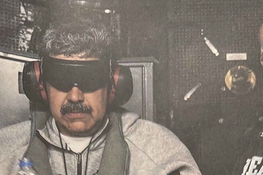 A photograph which U.S. President Donald Trump posted on his Truth Social account shows what he describes as Venezuelan President "Nicolas Maduro on board the USS Iwo Jima" amphibious assault ship, currently in the Caribbean Sea January 3, 2026. The image appears to be taken from a printed photograph, as white edging can be seen around the image. What appears to be the letters DEA can be seen on a black uniformed person next to Venezuelan president Maduro. U.S. president Trump said DEA officials were involved in the operation. Verifying the location was not immediately possible as the photograph is tightly cropped. But the patterning of grey hairs within Maduro's mustache matched recent imagery of him. @realDonaldTrump/Handout via REUTERS 
THIS IMAGE HAS BEEN SUPPLIED BY A THIRD PARTY. THIS PICTURE WAS PROCESSED BY REUTERS TO ENHANCE QUALITY. AN UNPROCESSED VERSION HAS BEEN PROVIDED SEPARATELY.     TPX IMAGES OF THE DAY