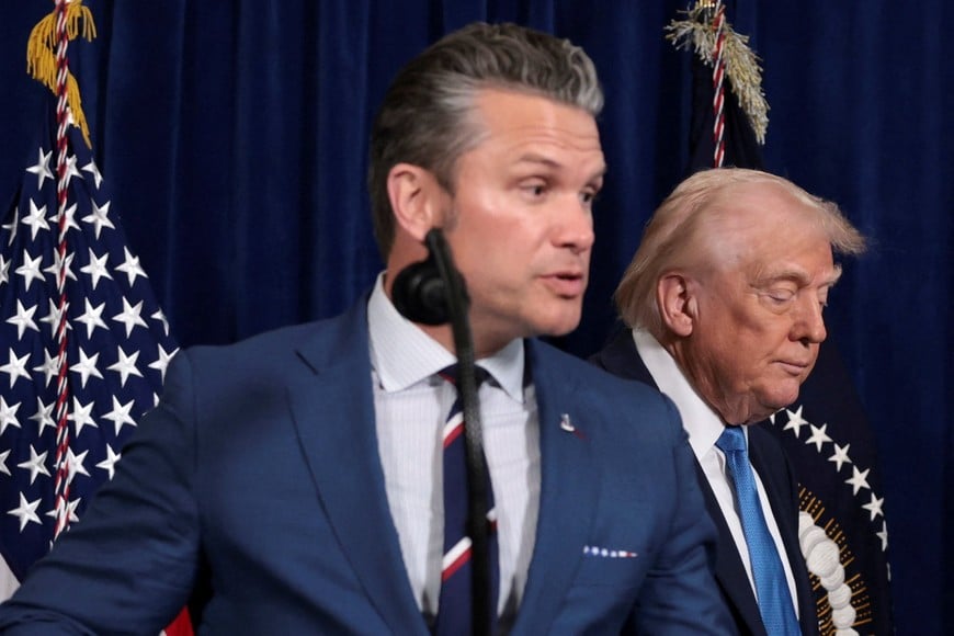 Secretary of Defense Pete Hegseth speaks during a press conference as U.S. President Donald Trump looks down following a U.S. strike on Venezuela where President Nicolas Maduro and his wife, Cilia Flores, were captured, from Trump's Mar-a-Lago club in Palm Beach, Florida, U.S., January 3, 2026. REUTERS/Jonathan Ernst