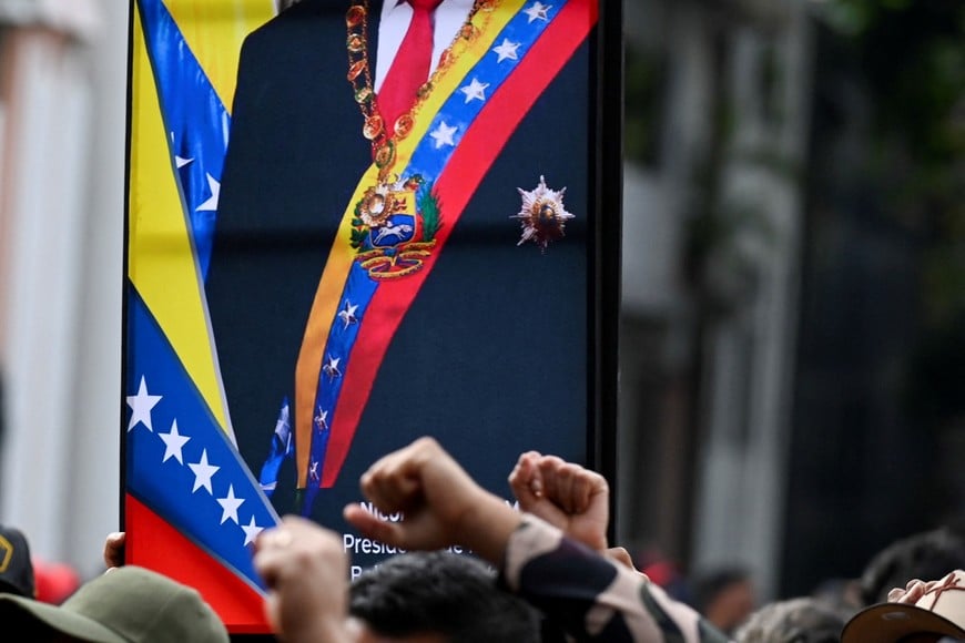 Government supporters gesture near a photograph of Venezuela's President Nicolas Maduro, after U.S. President Donald Trump said the U.S. has struck Venezuela and captured Maduro, in Caracas, Venezuela January 3, 2026. REUTERS/Maxwell Briceno