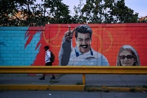 A man walks past a mural showing Venezuela's President Nicolas Maduro and his wife Cilia Flores, after U.S. President Donald Trump said on Saturday the U.S. has struck Venezuela and captured Maduro, in Caracas, Venezuela January 3, 2026. REUTERS/Maxwell Briceno