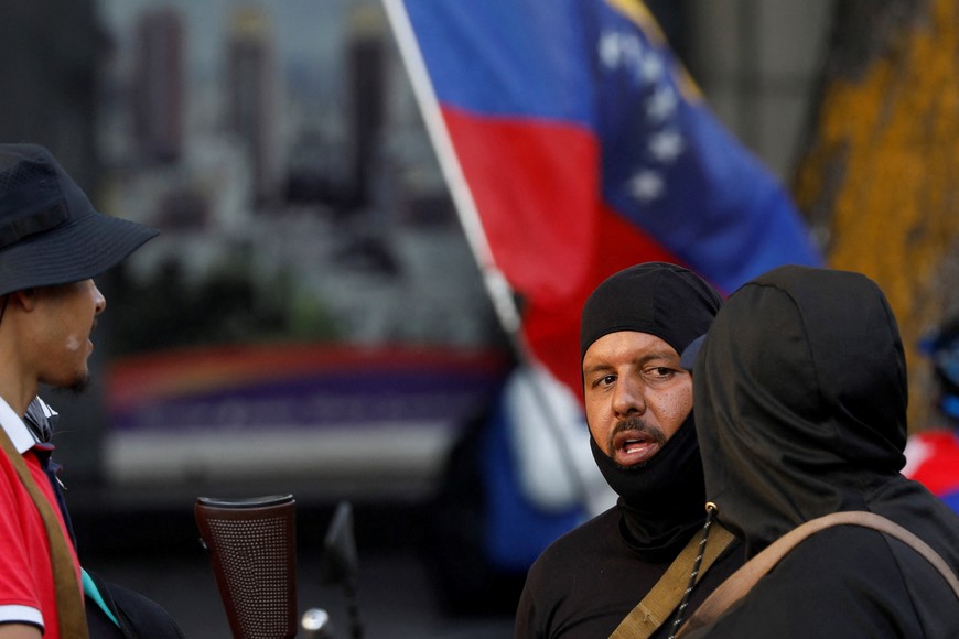 Members of the militia group known as "Colectivos" talk during a march calling for the release of Venezuela's President Nicolas Maduro, after he and his wife Cilia Flores were captured following U.S. strikes on Venezuela, in Caracas, Venezuela, January 4, 2026. REUTERS/Fausto Torrealba