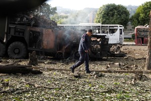 A firefighter walks past a destroyed anti-aircraft unit at La Carlota military air base, after U.S. President Donald Trump said the U.S. has struck Venezuela and captured its President Nicolas Maduro, in Caracas, Venezuela, January 3, 2026.  REUTERS/Leonardo Fernandez Viloria     TPX IMAGES OF THE DAY