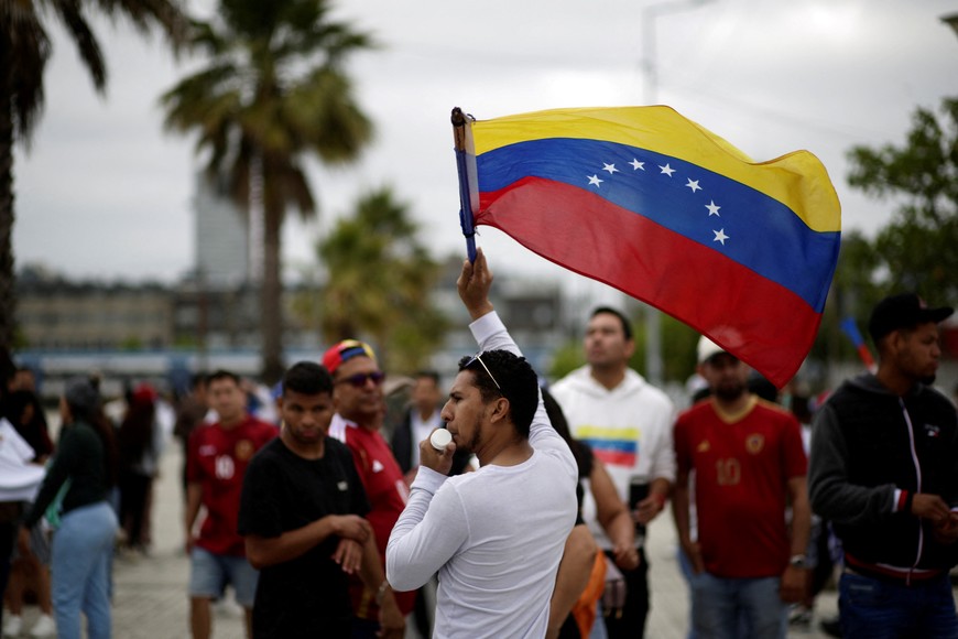 A man waves a Venezuelan flag as Venezuelans living in Chile gather to celebrate, after U.S. President Donald Trump announced that the United States struck Venezuela and captured its President Nicolas Maduro and his wife Cilia Flores overnight, in Concepcion, Chile, January 3, 2026. REUTERS/Juan Gonzalez