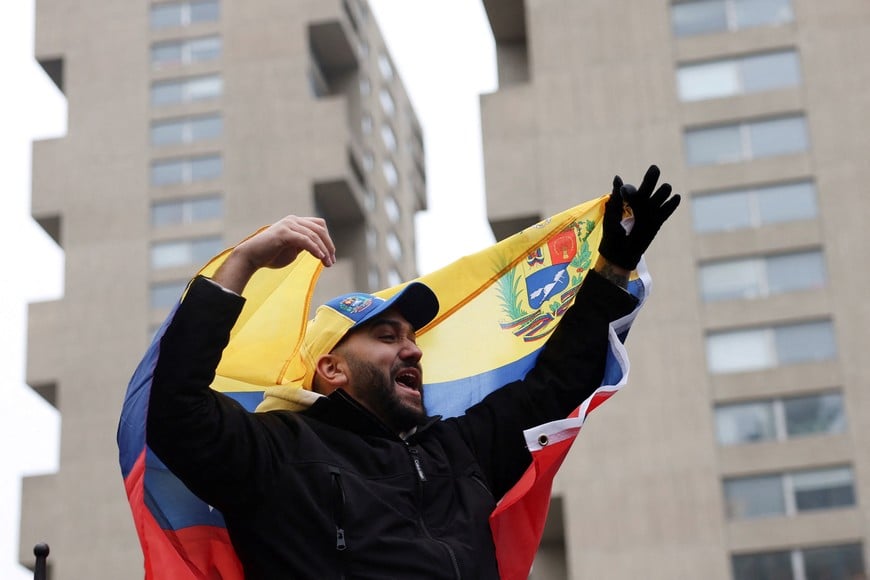 A person supporting the capture of Venezuelan President Nicolas Maduro displays a Venezuelan flag, as people protest against U.S. strikes against Venezuela and the capture of Maduro, outside the Daniel Patrick Moynihan United States Courthouse ahead of his arraignment to face U.S. federal charges including narco-terrorism, conspiracy, drug trafficking, money laundering and others in New York City, U.S., January 5, 2026. REUTERS/Shannon Stapleton