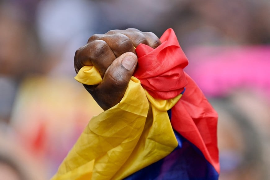 A demonstrator holds a Venezuelan flag during a march outside the National Assembly on the day Vice President Delcy Rodriguez was formally sworn in as Venezuela's interim president, as U.S.-deposed President Nicolas Maduro appeared in a New York court after the Trump administration removed him from power, in Caracas, Venezuela January 5, 2026. REUTERS/Maxwell Briceno
