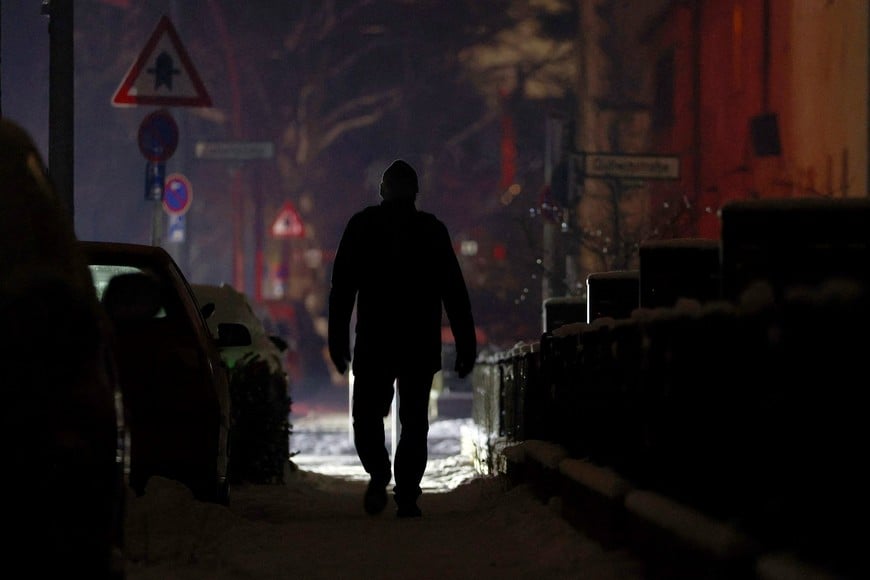 A person walks along a street during a blackout, which left thousands of homes without power after a suspected arson attack at the Lichterfelde power plant in the Steglitz-Zehlendorf district in southern Berlin, Germany, January 6, 2026. REUTERS/Lisi Niesner