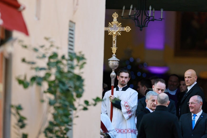 Officials and mass servers stand at the entrance of the Notre-Dame-de-l’Assomption church before the funeral service for the late French film icon Brigitte Bardot at in Saint-Tropez, France, January 7, 2026. REUTERS/Manon Cruz
