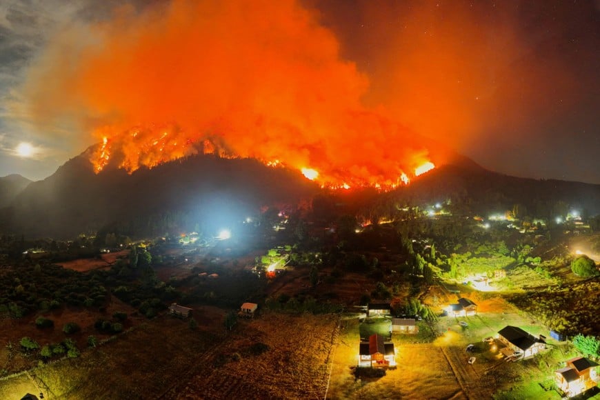 A drone view shows smoke and flames rising from trees as a wildfire develops, in El Hoyo, in the Patagonian province of Chubut, Argentina January 7, 2026. REUTERS/Maxi Jonas     TPX IMAGES OF THE DAY