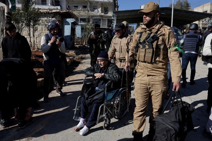 A man is assisted as he evacuates from Sheikh Maksoud neighbourhood following the collapse of an agreement between the Syrian government and the Syrian Democratic Forces (SDF), in Aleppo, Syria, January 10, 2026. REUTERS/Khalil Ashawi