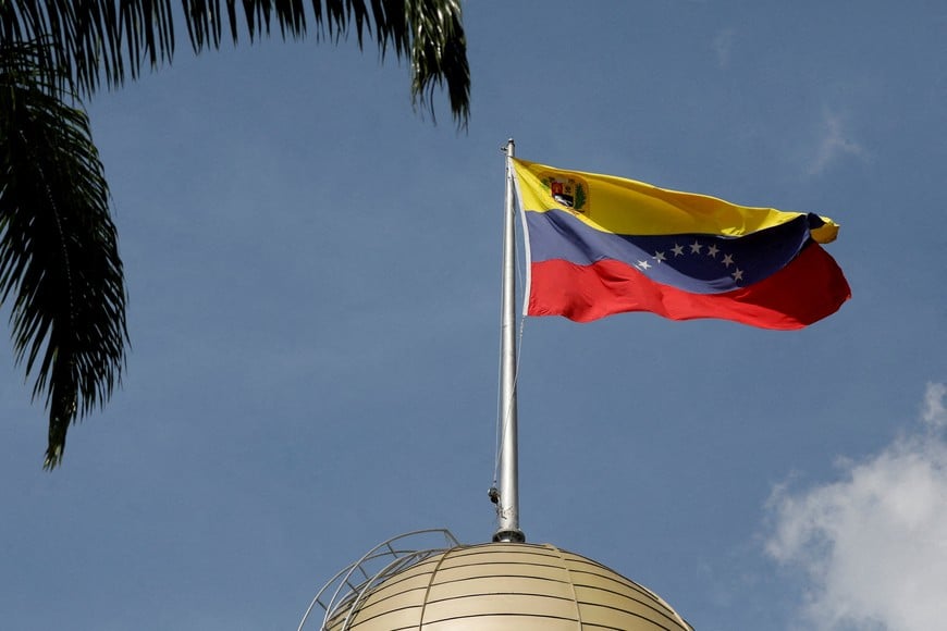 FILE PHOTO: The Venezuelan flag flies atop the National Assembly on the day of the swearing-in ceremony of Vice President Delcy Rodriguez as Venezuela’s interim president, after the U.S. launched a strike on the country and captured President Nicolas Maduro and his wife Cilia Flores, in Caracas, Venezuela, January 5, 2026. REUTERS/Fausto Torrealba/File Photo