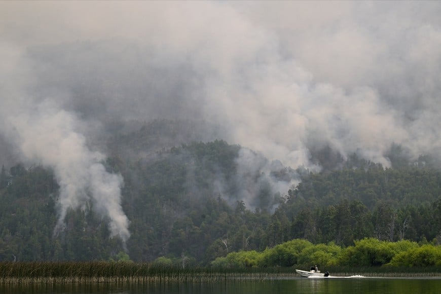 A boat moves across the Lago Epuyen lake during a wildfire in the Patagonian province of Chubut, Argentina January 7, 2026. REUTERS/Maxi Jonas