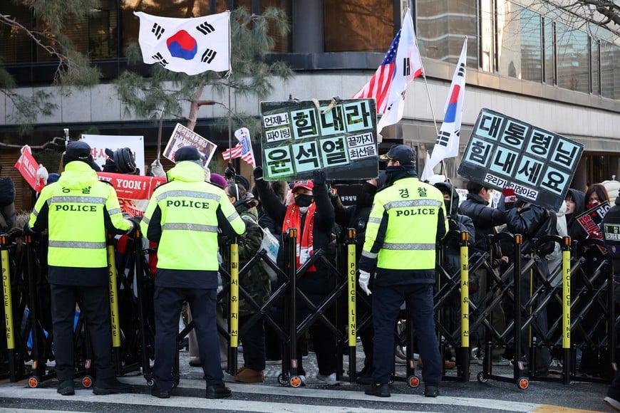 A group of far right wing protesters gathers to support former President Yoon Suk Yeol, as a bus carrying him arrives for the final arguments in his insurrection trial, at a court in Seoul, South Korea, January 13, 2026. The banner reads "Cheer up Yoon Suk Yeol."  REUTERS/Kim Hong-Ji