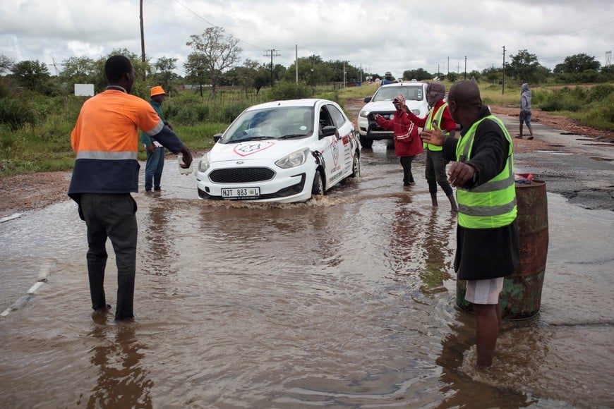 People assist motorists through a waterlogged road after heavy rains caused severe flooding and property damage in Phalaborwa, Limpopo, South Africa, January 16, 2026. REUTERS/Oupa Nkosi