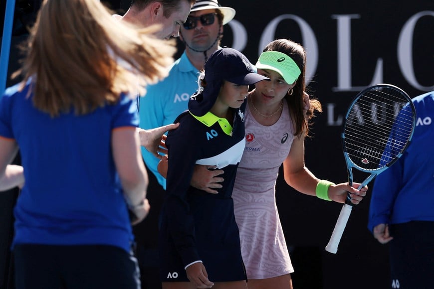 Tennis - Australian Open - Melbourne Park, Melbourne, Australia - January 18, 2026
Turkey's Zeynep Sonmez helps a ball kid after they collapsed due to heat during her first round match against Russia's Ekaterina Alexandrova REUTERS/Edgar Su