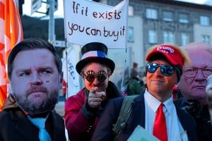Activists wearing masks of Rheinmetall CEO Armin Papperger and U.S. Vice President JD Vance stand next to a person wearing a costume depicting U.S. President Donald Trump, during a protest ahead of the opening of the World Economic Forum (WEF) in Davos, Switzerland, January 18, 2026. REUTERS/Denis Balibouse