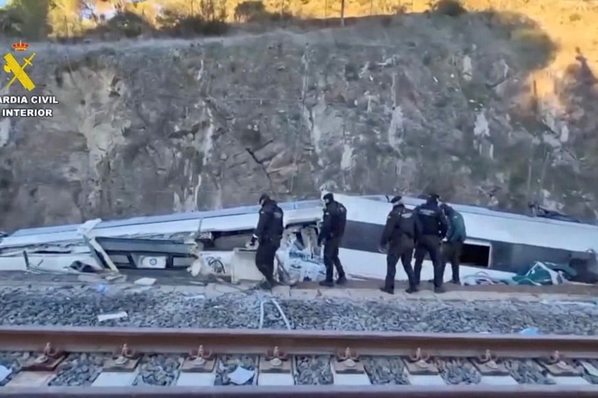 Emergency personnel walk at the site of a deadly collision of two high-speed trains near Adamuz, in Cordoba, Spain, January 19, 2026 in this screengrab taken from a video. Guardia Civil/via Reuters TV/Handout via REUTERS    THIS IMAGE HAS BEEN SUPPLIED BY A THIRD PARTY. MUST NOT OBSCURE LOGO.