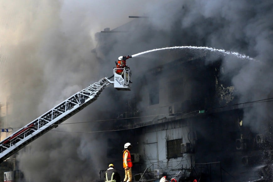 (260119) -- KARACHI, 19 enero, 2026 (Xinhua) -- Imagen del 18 de enero de 2026 de bomberos intentando extinguir un incendio que se ha declarado en un centro comercial, en Karachi, Pakistán. El número de muertos por un incendio ocurrido en un centro comercial en la ciudad portuaria de Karachi, en el sur de Pakistán, ascendió a 14 el lunes por la mañana, después de que los equipos de rescate recuperaran más cadáveres durante una operación de búsqueda, según informaron las autoridades. (Xinhua) (oa) (ah) (vf)