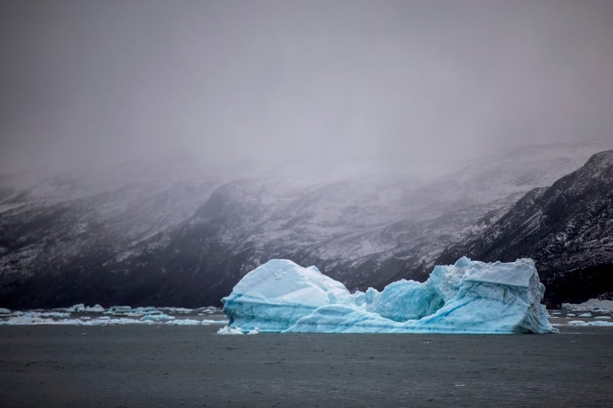 An iceberg floats in front of foggy mountains in the north of Ilulissat, Greenland, September 15, 2021. Picture taken September 15, 2021.  REUTERS/Hannibal Hanschke