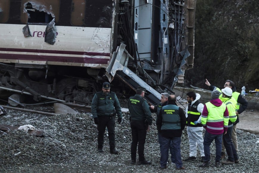 Members of the Spanish Civil Guard and ADIF stand near the wreckage of a train involved in the accident, at the site of a deadly derailment of two high-speed trains near Adamuz, in Cordoba, Spain, January 20, 2026. REUTERS/Susana Vera