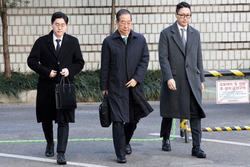 SEOUL, SOUTH KOREA - JANUARY 21: Former South Korean Prime Minister Han Duck-soo (C) arrives at the Seoul Central District Court for his first sentencing trial in the insurrection case on January 21, 2026 in Seoul, South Korea.     Chung Sung-Jun/Pool via REUTERS