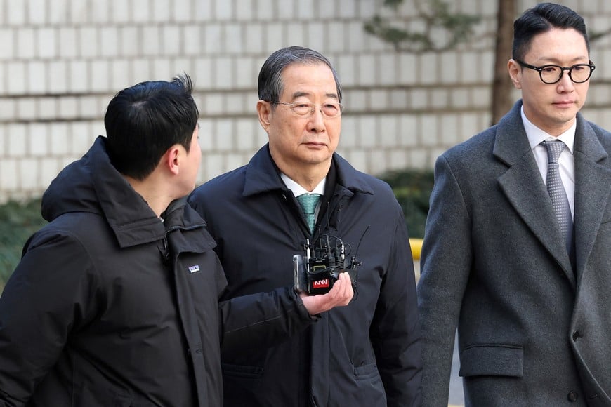 SEOUL, SOUTH KOREA - JANUARY 21: Former South Korean Prime Minister Han Duck-soo (C) arrives at the Seoul Central District Court for his first sentencing trial in the insurrection case on January 21, 2026 in Seoul, South Korea.     Chung Sung-Jun/Pool via REUTERS