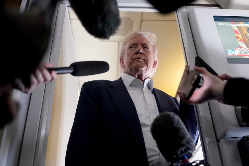 U.S President Donald Trump speaks to members of press onboard Air Force One on a flight to Fiumicino Airport near Rome to attend the funeral of Pope Francis, April 25, 2025. REUTERS/Nathan Howard     TPX IMAGES OF THE DAY