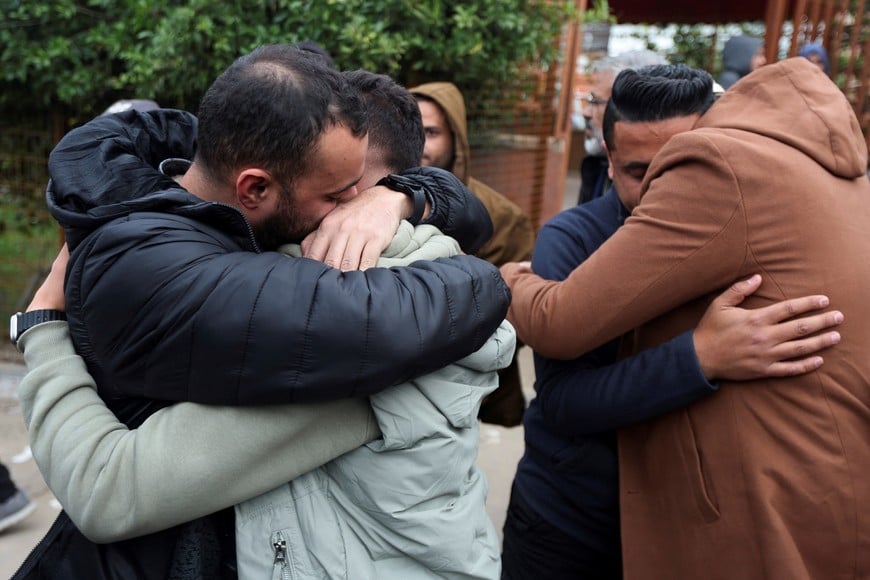Mourners hug each other during a funeral of one of the Palestinian journalists killed in an Israeli airstrike on Wednesday, in Khan Younis, in the southern Gaza Strip, January 21, 2026. REUTERS/Ramadan Abed
